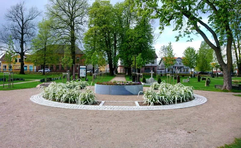 Vakkert sirkulært blomsterbed i midten av gravplassen. Foto.